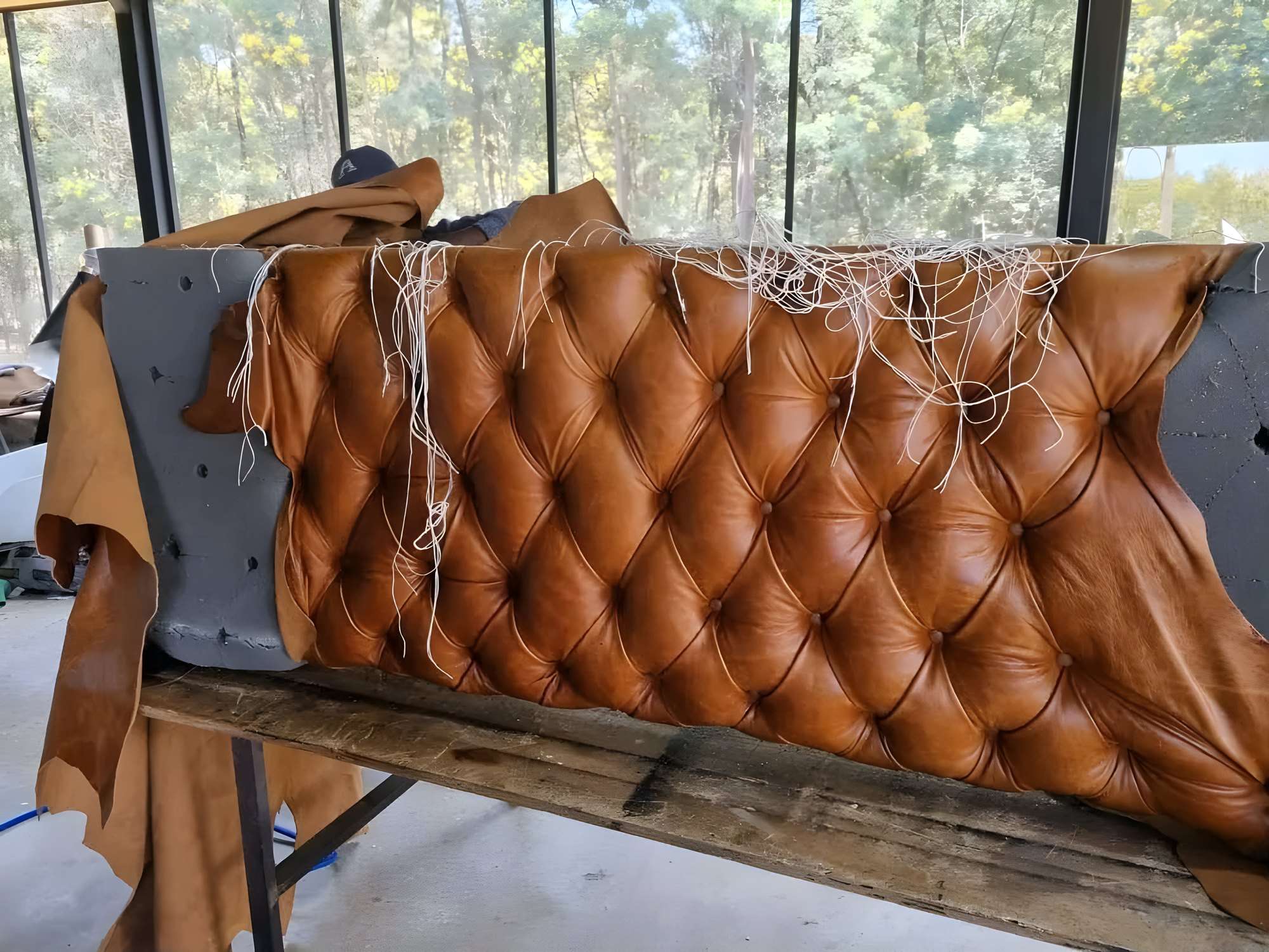 Buttoned tan leather headboard being made in the workshop