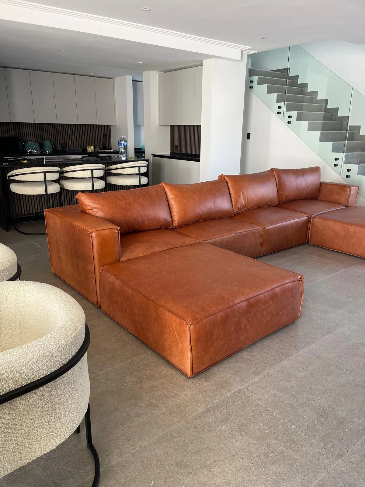 Tan leather corner couch back in a customer’s lounge