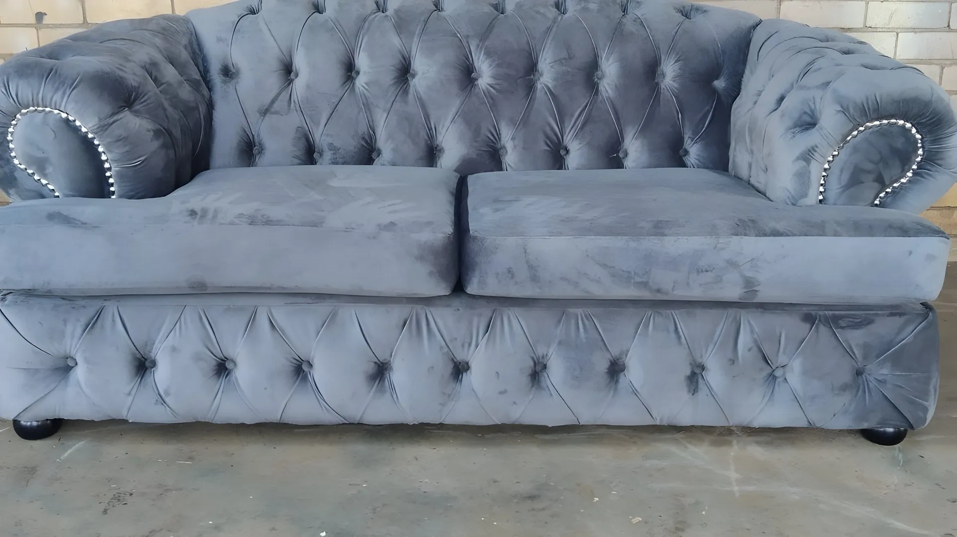 After: Brown pillow-back couch, rebuilt as a grey buttoned chesterfield