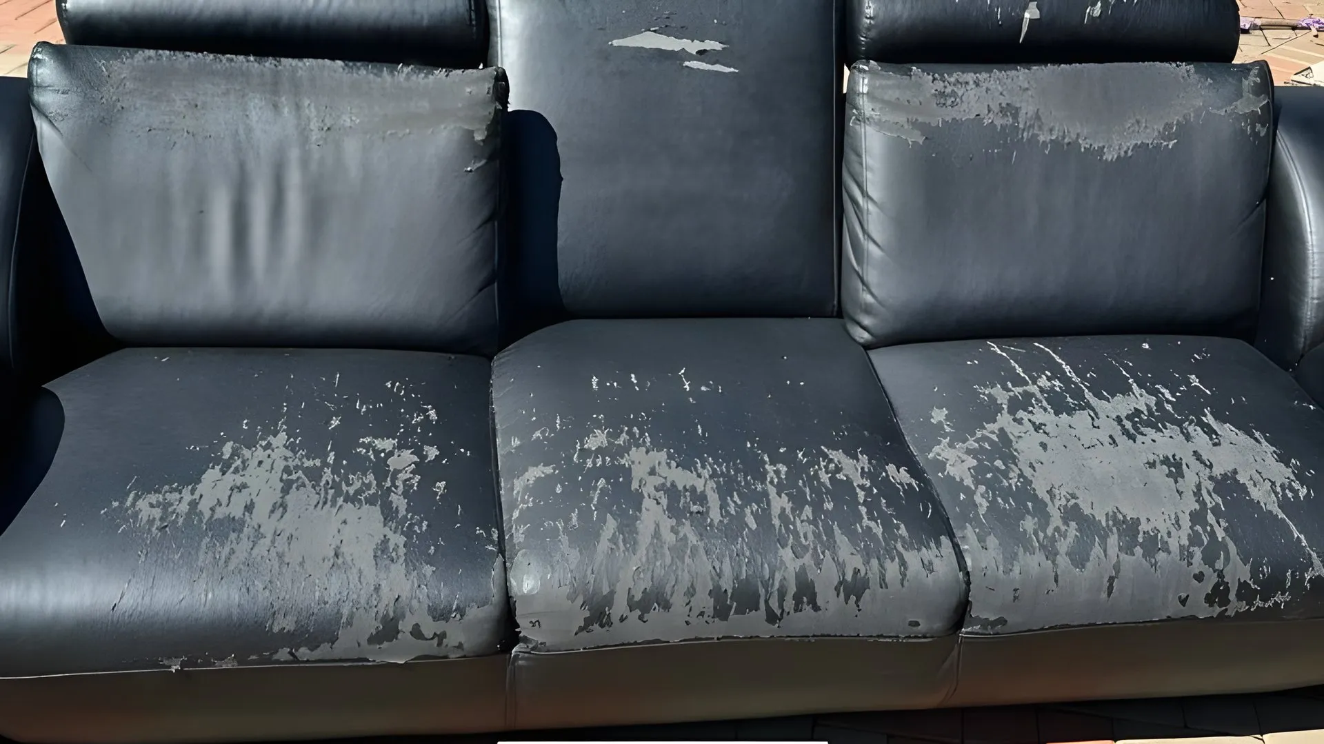 Before: Peeling black leather couch, redone in red