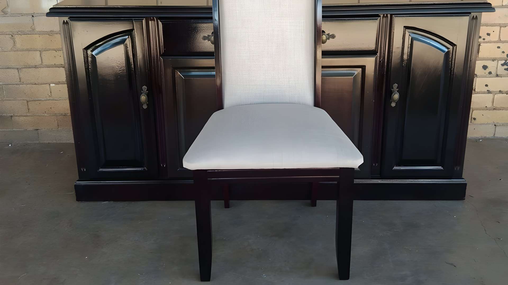 Refinished dark wood sideboard with a dining chair re-covered in light grey fabric