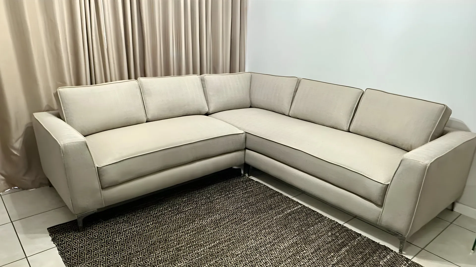 After: Worn brown-and-grey corner suite, re-covered in oatmeal fabric