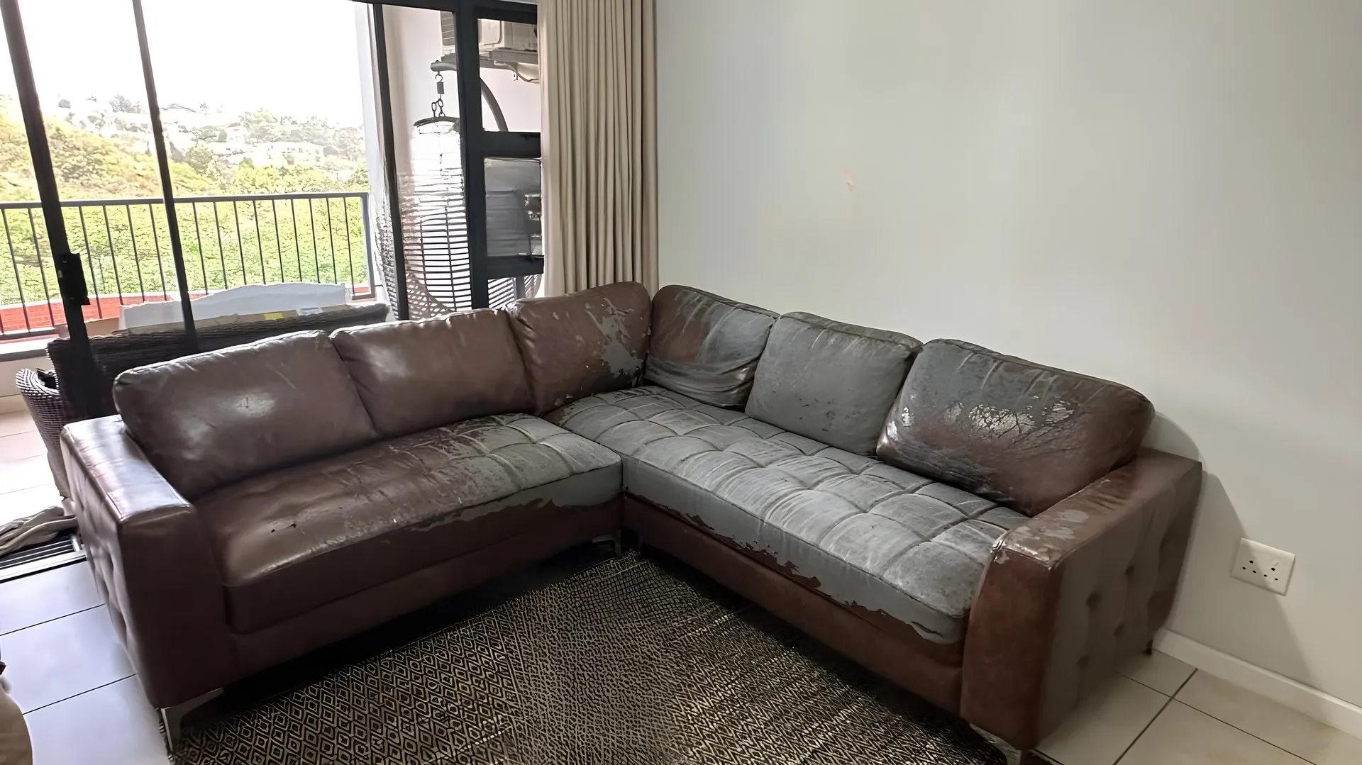 Before: Worn brown-and-grey corner suite, re-covered in oatmeal fabric