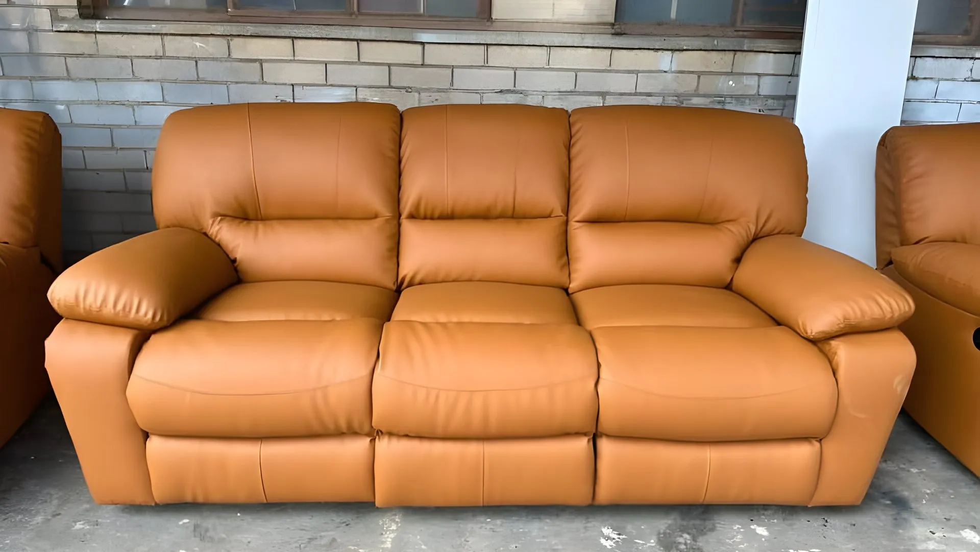 After: Peeling brown three-seater recliner, redone in tan