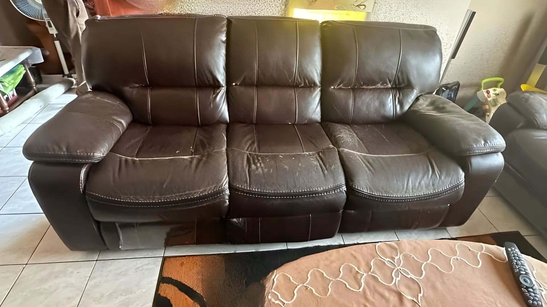Before: Peeling brown three-seater recliner, redone in tan