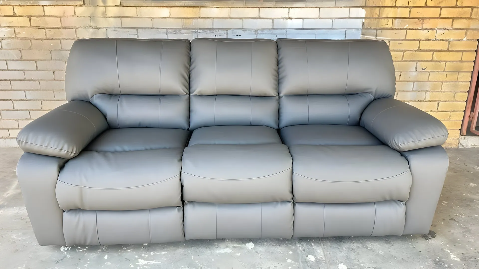 After: Cracked grey three-seater recliner, re-covered in grey