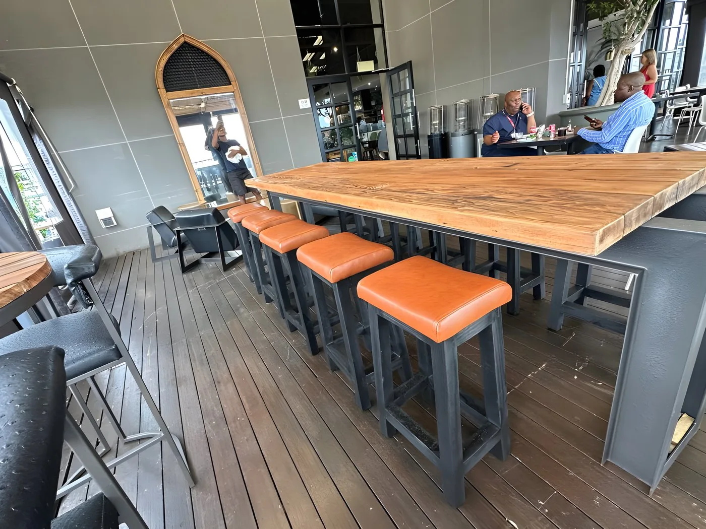 Long bar table with tan leather bar stools