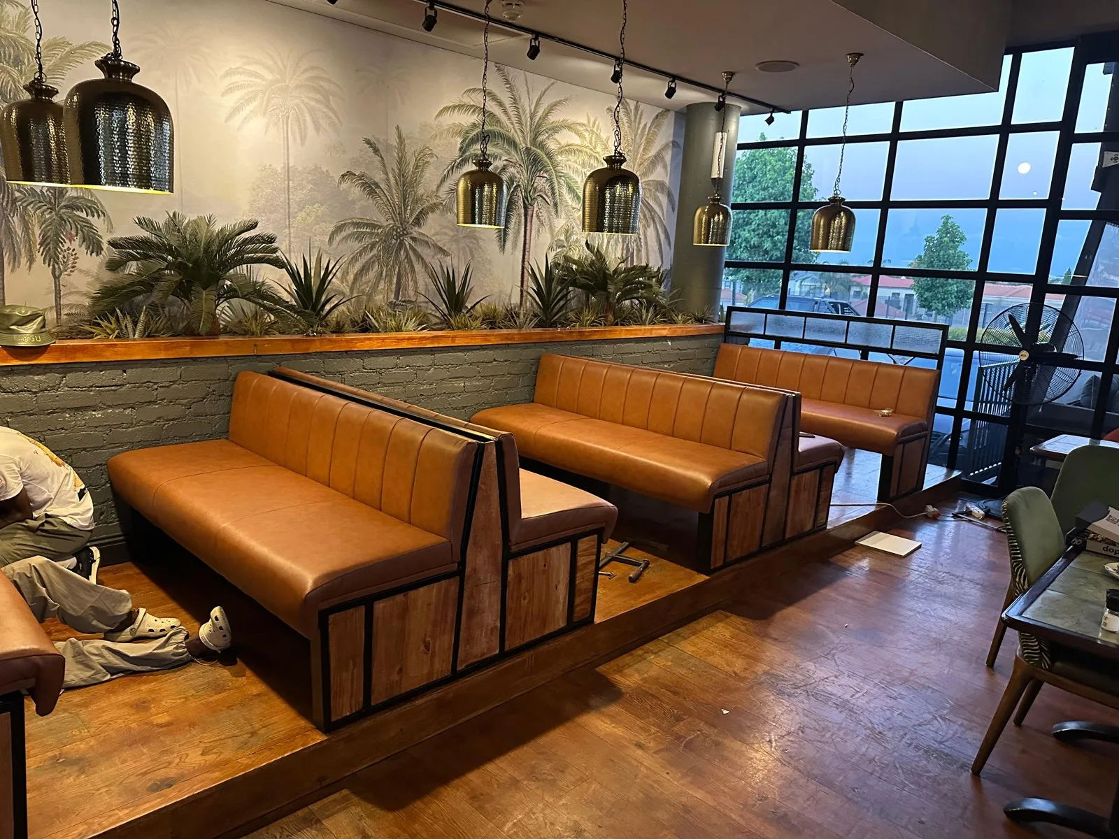 Tan leather restaurant booths with wooden bases