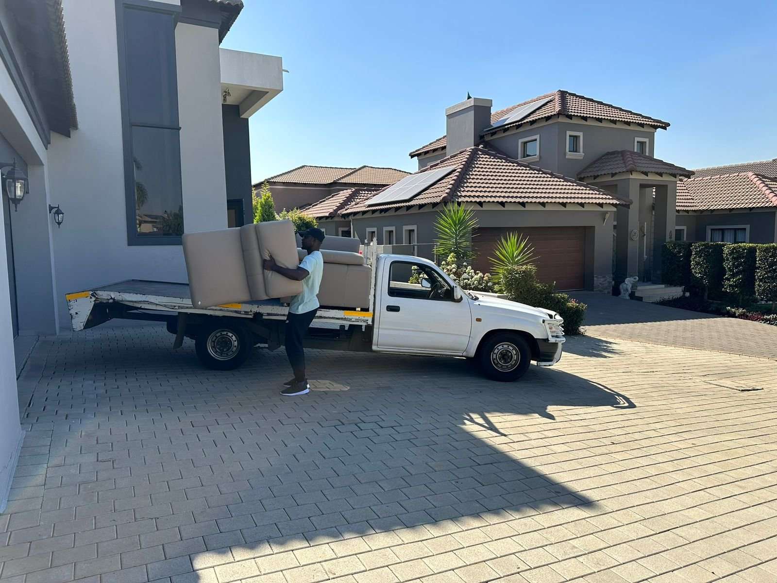 Our bakkie outside a customer's house with a couch being loaded