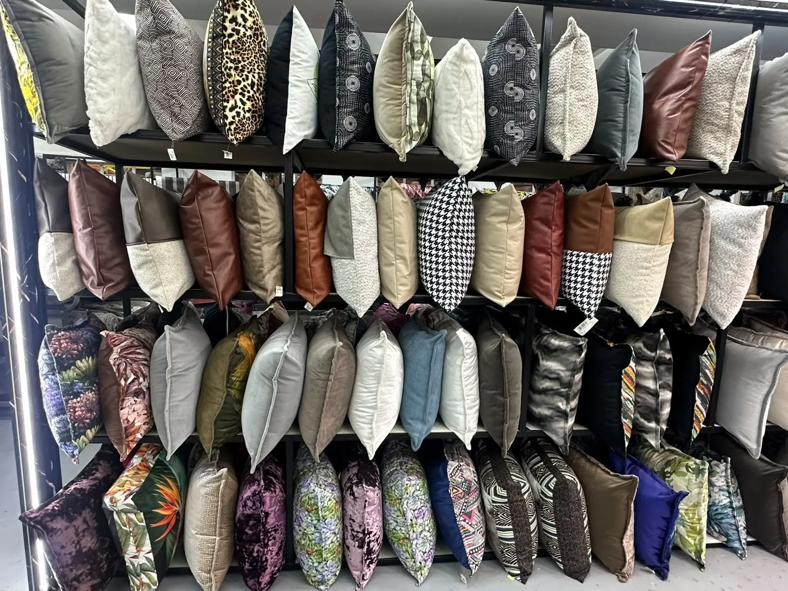 A wall of accent cushions in velvets and patterned fabrics