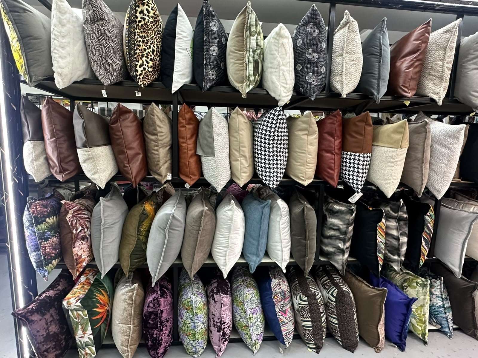 A wall of accent cushions in velvets and patterned fabrics
