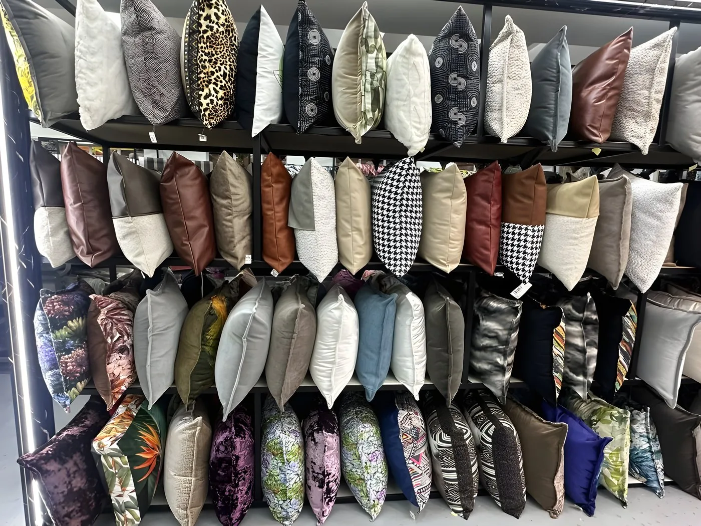 Wall of accent cushions in velvets and patterned fabrics